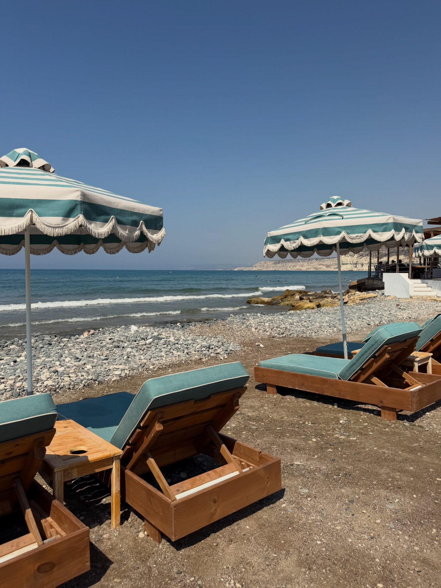 Striped umbrellas and sun loungers on a Mediterranean beach